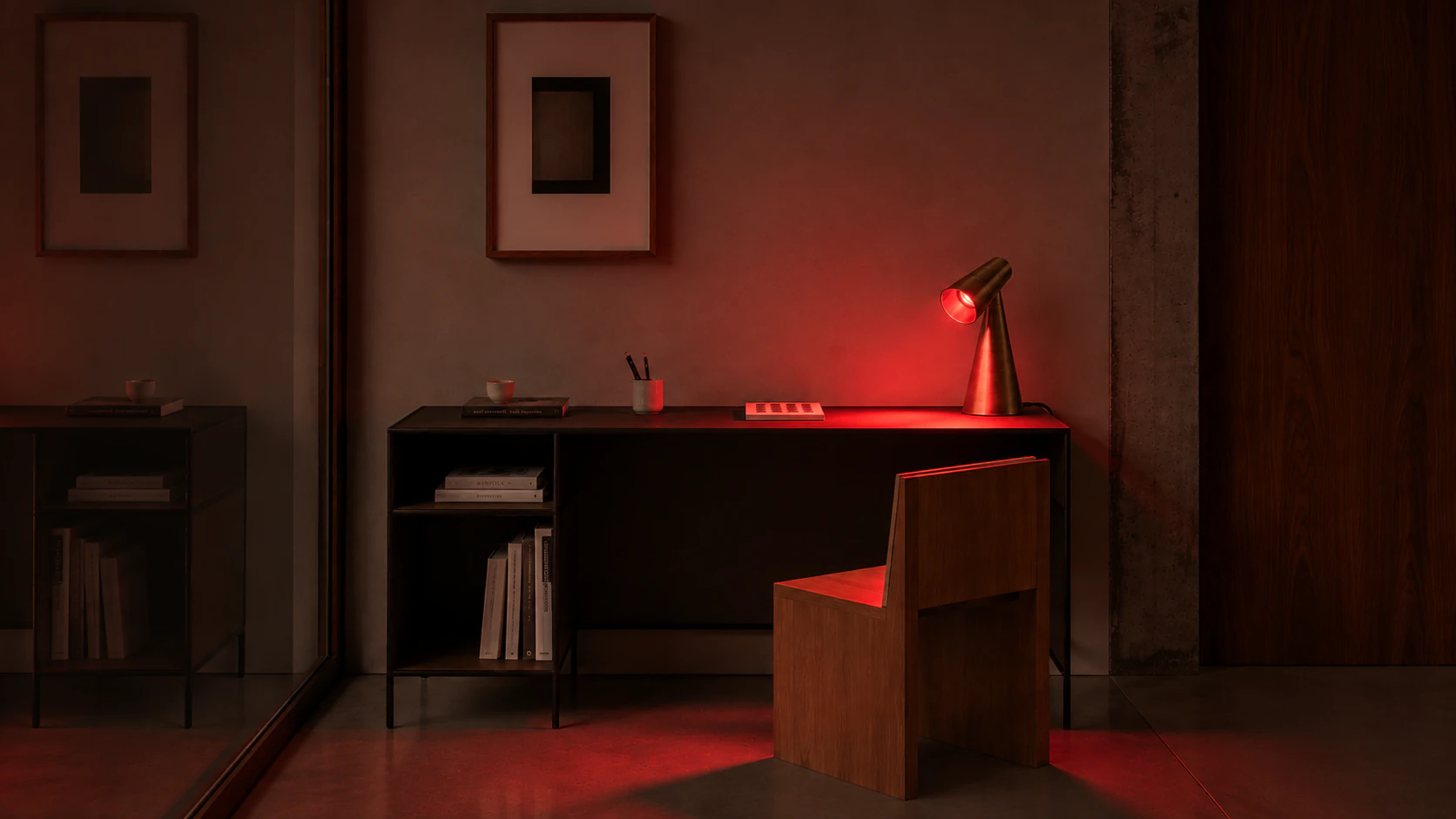 Milieu lamp casting red light across a desk at night